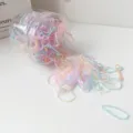 Vista dettagliata di elastici per capelli colorati fuoriusciti da un barattolo trasparente. - Colore Gelatina