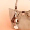 Close-up detail of natural plant pod bag charm with wooden beads and healing forest style. - 06