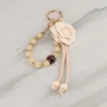 Llavero elegante de cuentas con flor de camelia y cordón trenzado como accesorio de bolso. - Colgante 13