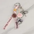 Detailed view of a cute pink ribbon keychain charm with beads and metal 8-ball pendant. - Charm 15