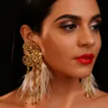 Detailaufnahme von goldenen Kristall-Feder-Fransen-Ohrringen, elegantes Schmuckstück. - Gold / Herz Ohrringe