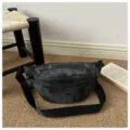 Vista dettagliata della borsa a tracolla con motivo grigio scuro, cinturino nero e zip. - Nero