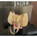 Vista dettagliata della borsa a spalla in paglia elegante con cinturino in pelle e fibbia. - Kaki