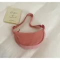 Primo piano dettagliato della borsa a tracolla in nylon rosa su uno sfondo di tessuto. - Rosa
