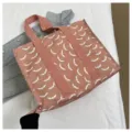 Detailansicht der stilvollen rosa Segeltuch-Tragetasche mit weißem Fledermausmuster und Henkeln. - Rosa