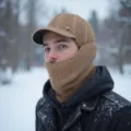 Detalle de gorro de punto de invierno con orejeras cálidas y cuello protector. - Caqui