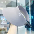 Gedetailleerd overzicht van brede grijze zonneklep met voorlogo en verstelbare band. - Verstelbaar / Lichtgrijs