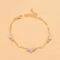 Gold rhinestone anklet detail showcasing sparkly teardrop crystals and dainty chain links. - Gold