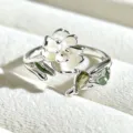 Close-up detail shot of a sweet enamel white flower ring with green leaves and a crystal stone. - Adjustable Open / 3D White Flower with Green Stone Style (JZ2233A) / Silver