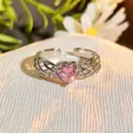 Detailed close-up of a silver open ring with a sparkling pink heart zirconia and delicate wing details. - Adjustable Open / Pink Diamond Openwork Wing (JZ6114)