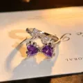 Close-up detail of silver open ring featuring double bow design with purple zirconia and paved stones. - Double Bow Heart Style (JZ0511A) / Adjustable Open