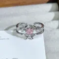 Detail view of silver open ring featuring a sparkling pink zircon center stone and bow design. - Bowknot Pink Zirconia Style (JZ2948A) / Silver