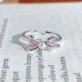 Close-up view of the silver open ring showcasing a bow, pink heart zirconia, and a pearl. - Pearl Heart Bowknot Style (JZ0586A)