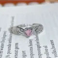 Close-up of a silver open ring featuring a pink heart-shaped cubic zirconia and wing details. - Hollow Wings Heart Style (JZ6114)