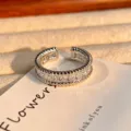 Gedetailleerde close-up van de open zirkonia ring met vierkante stenen en elegant gedraaide band. - Verstelbaar Open / Vierkante Zirconia Rij Touw Rand Stijl (JZ0445A)