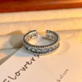 Open zilverkleurige ring met een rij vierkante blauwe zirkonia's en gedraaide touwmetaalranden. - Verstelbaar Open / Lichtblauwe Zirconia Touw Rand Stijl (JZ0464B)