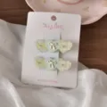 Primo piano dettagliato della molletta per capelli a cuore con motivo a quadri e strass. - Cuore A Tripla Toppa A Quadri Verde