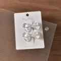 Close-up detail view of cute translucent floral bow hair clips on branded packaging card. - 2 Large Bows / 2 Pieces/Pack / Purple Series