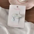 Primo piano dettagliato di dolce fermaglio per capelli a cuore con ciondolo floreale. - Anello Blu Grande Cuore
