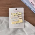Detail shot of cute pastel hair clips set featuring bow and floral designs on backing card. - Set of 4 / Yellow Series Hollow Bowknot