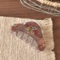 Primo piano del fermaglio per capelli in resina marrone con dettagli di fiori in strass colorati. - Fermaglio per Capelli Triangolare Rotondo Marrone 9cm (FJ911)