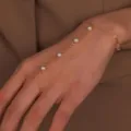 Detailaufnahme eines filigranen Gold Handketten Armbands mit Perlen für elegante Frauen. - Gold Künstliche Perle Armband Stil