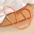 Detailed close-up of orange heishi disc bead necklace with LOVE letter beads and gold accents. - Multifunctional Chain / Color 6