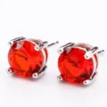 Primo piano di orecchini a perno in zircone rosso da 7 mm con montatura a quattro griffe. - Rosso