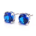 Primo piano dettaglio di orecchini a lobo in zircone blu rotondo con montatura in argento. - Blu Zaffiro