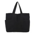Black nylon tote bag detail showing the durable fabric, side pockets and sturdy straps. - Black