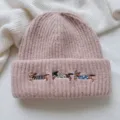 Close-up detail of the cute pink knit beanie featuring adorable embroidered dachshund dogs. - Hat / Pink