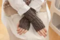 Detaillierte Nahaufnahme von braunen Strick-Fingerlosen Handschuhen, ideal für den Winter. - Dunkelgrau