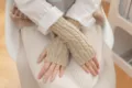 Nahaufnahme von beige Zopfmuster Strick-Fingerlosen Handschuhen, warmes Wintermode-Accessoire. - Beige