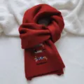 Detailed view of the red knitted wool blend scarf featuring cute dachshund embroidery. - Scarf / Red