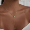 Nahaufnahme einer goldenen Y-Halskette mit funkelnden Strass-Kleeblatt-Anhängern. - 吊坠项链款 / Gold