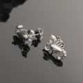 Primer plano detallado de pendientes de botón de escorpión gótico en acero de titanio. - Color acero