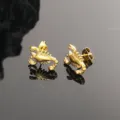 Detalle de cerca de pendientes de tachuela de escorpion de acero titanio para hombres. - Dorado