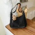 Stylish black hobo shoulder bag with cute puppy plush charm, casual chic design for women. - Black