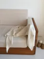 Detailed view of a warm beige hollow knitted wool triangular shawl scarf for women styling. - Ivory