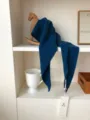 Primer plano del detalle de la bufanda triangular de lana azul oscura con etiqueta. - Azul marino