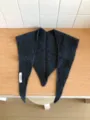 Detailed view of the dark grey wool knit triangular scarf, showing soft texture and cozy wear. - Dark Gray