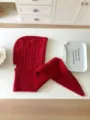 Red knitted hooded scarf detail, thick cable knit texture, cozy winter fashion accessory. - Red