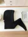 Black knitted balaclava hood scarf detail shot flat lay textured fabric winter fashion - Black