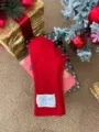 Rote Strick-Winterhandschuhe Nahaufnahme Detail mit festlichem Weihnachtsgeschenk-Hintergrund. - Rot