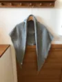 Detail view of the cozy grey wool triangular scarf with soft fringe edges for winter warmth. - Light Gray