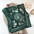 Detailed view of a dark green silk scarf featuring classic carriage and paisley patterns. - Green Horse
