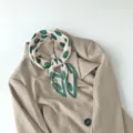 Detailed view of a pleated printed square scarf featuring chic green polka dots on pink fabric. - Green