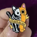Close-up detail of Halloween dark style split cat enamel pin badge with cool aesthetic. - Dead & Alive Cat