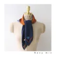 Detailed shot of a navy blue satin square scarf with orange border and heart pattern. - Blue