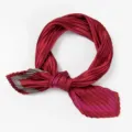 Close-up view of elegant red pleated square silk scarf with geometric striped border details. - Pleated Style / Wine Red Border